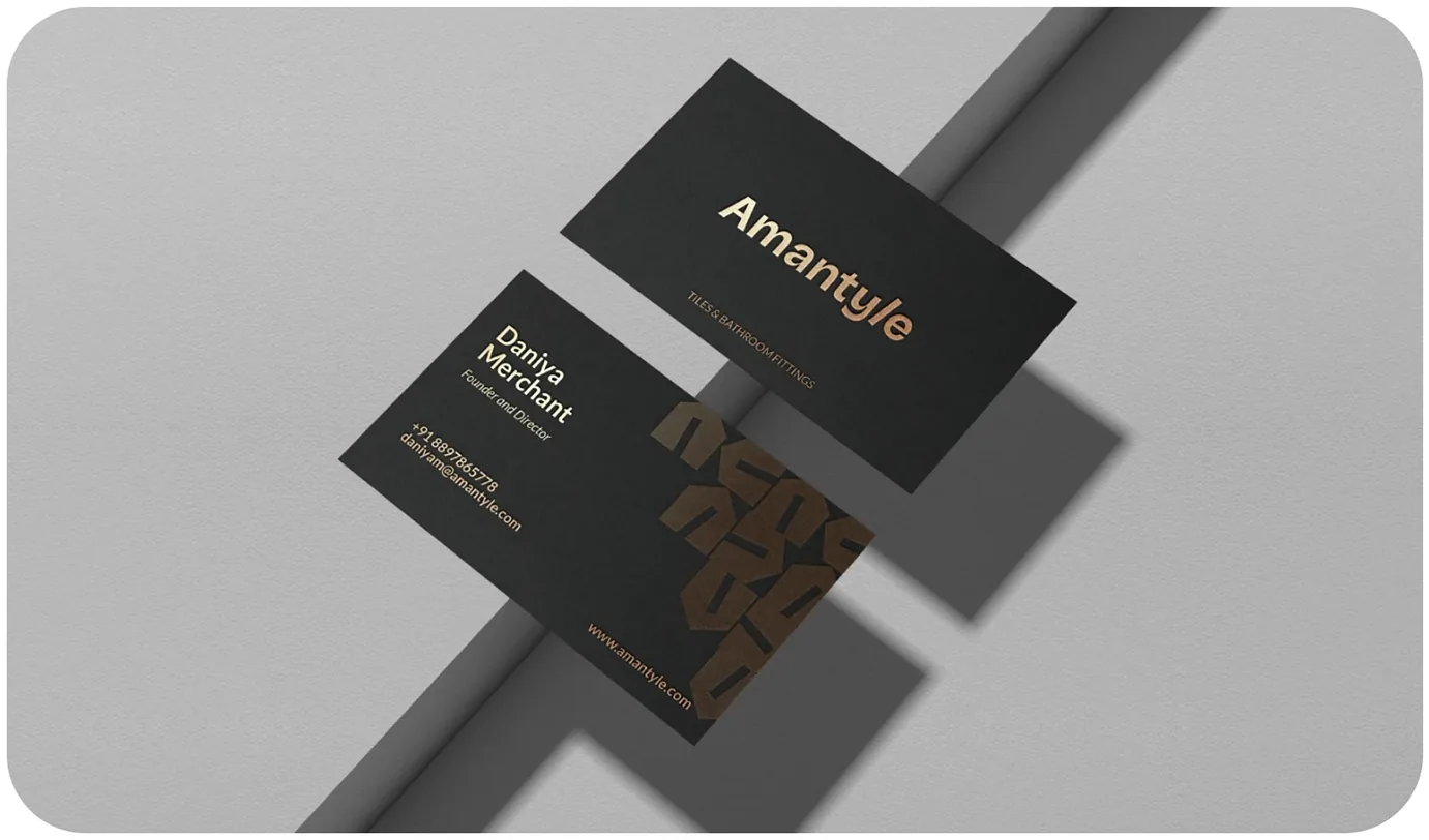 Two black business cards: one with the Amantyle wordmark, one with a name, contact details and the tile pattern.