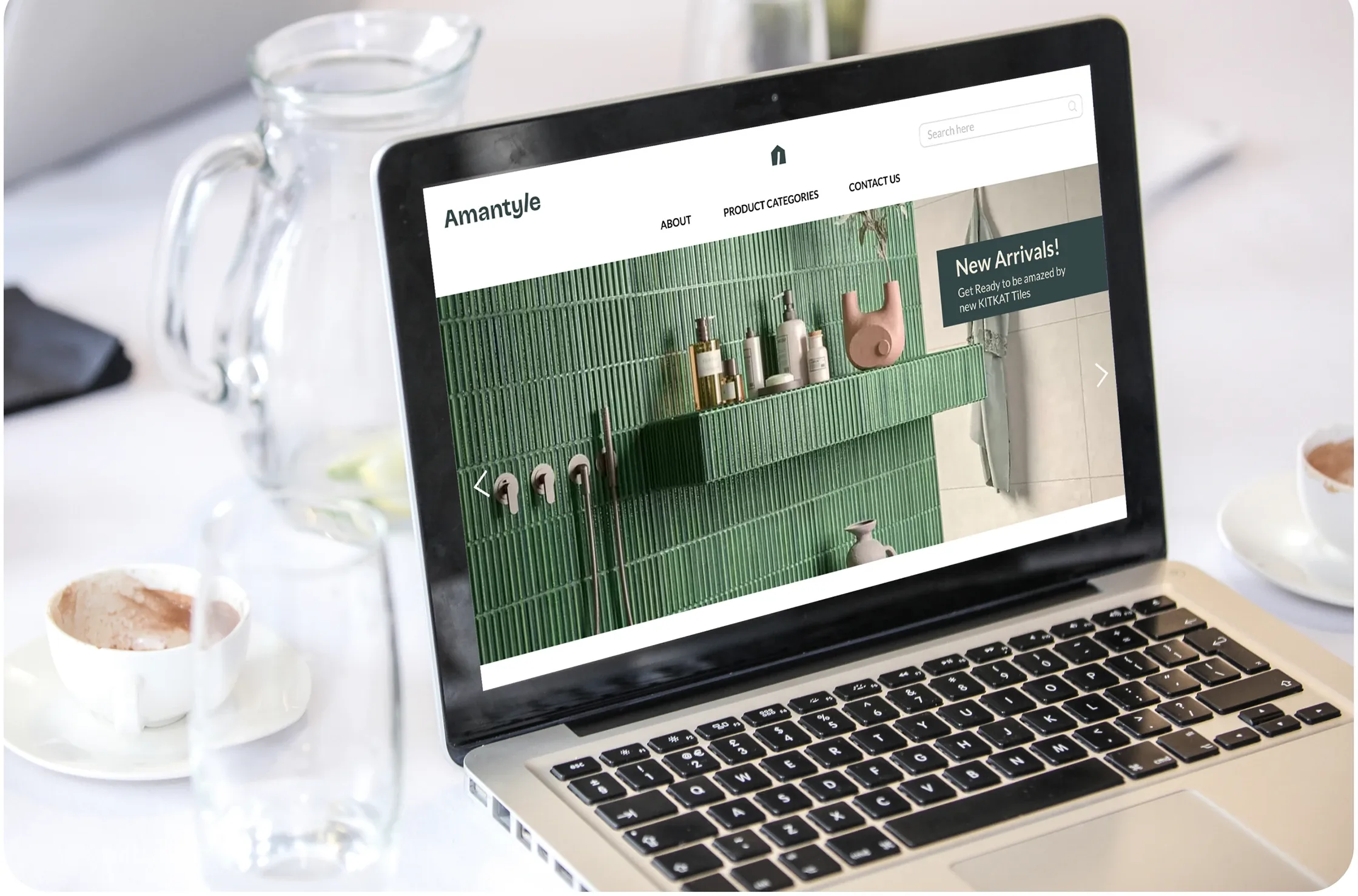 A laptop showing the Amantyle website: the wordmark and house mark, a navigation bar, and a hero of green tiles with a New Arrivals panel.